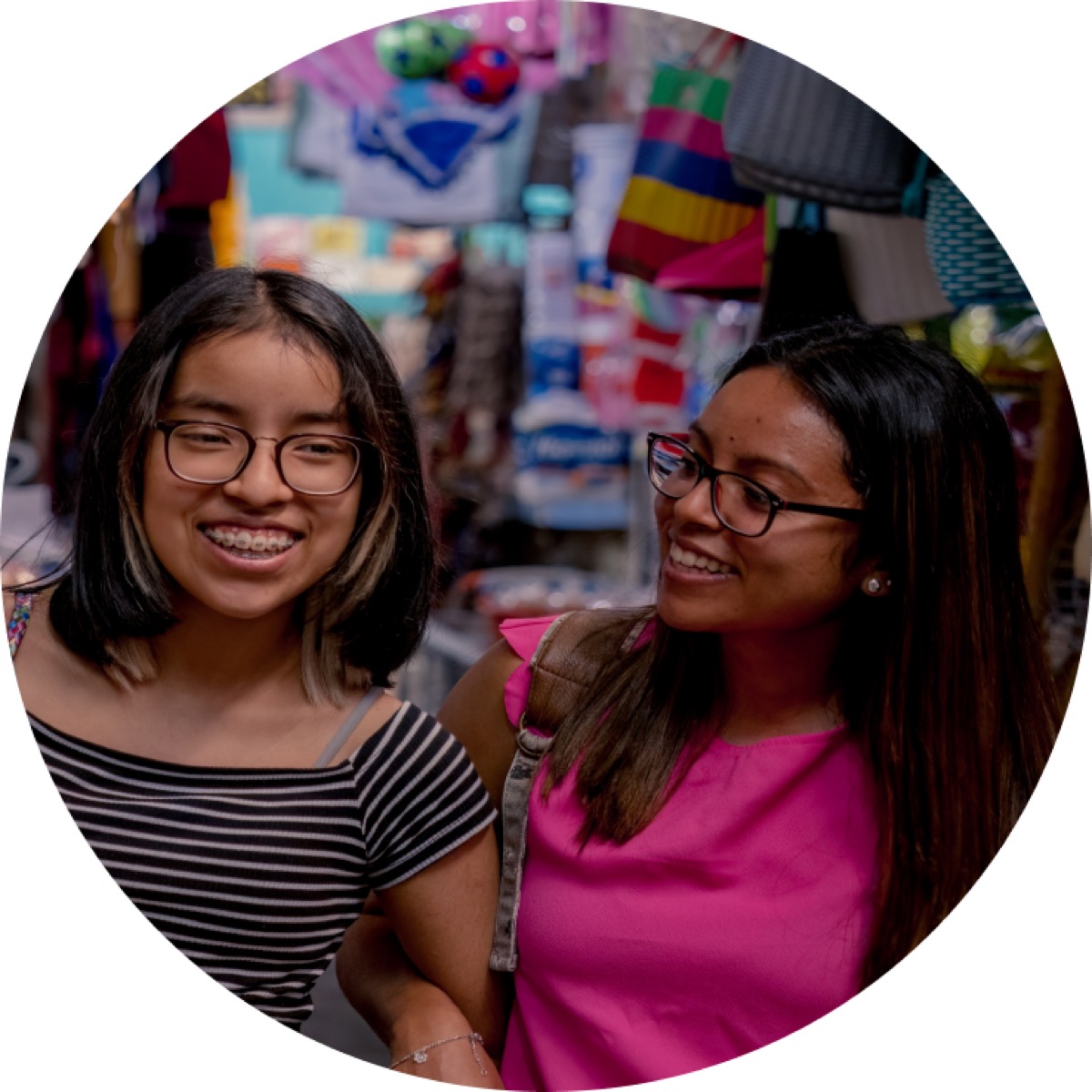 Two teenage girls laughing together while out shopping